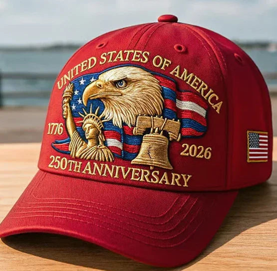 Red embroidered baseball cap featuring bald eagle, Statue of Liberty, Liberty Bell, and US flag