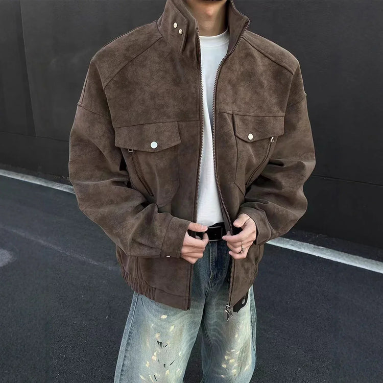Man wearing oversized brown suede jacket with front snap pockets, white shirt, loose fit jeans