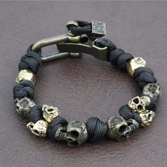 Black rope bracelet with metallic skull beads, industrial clasp, edgy streetwear style