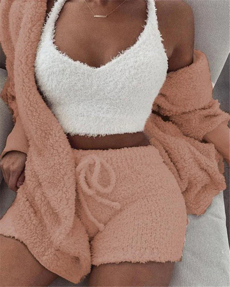 Woman wearing a fuzzy white crop top with peach textured shorts and a matching cardigan