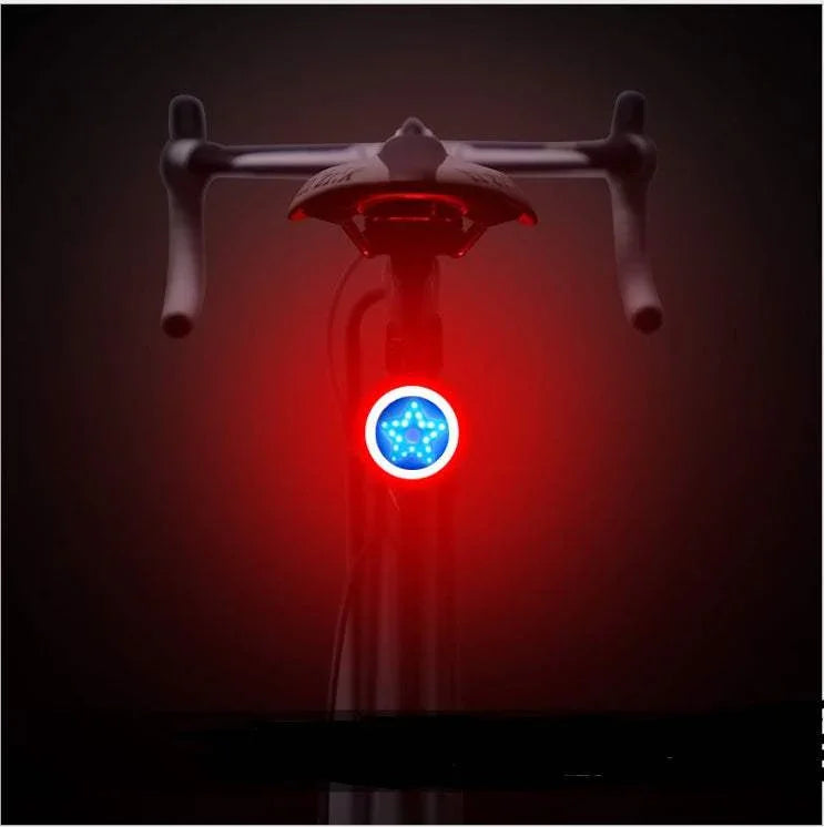 Bicycle rear view with illuminated red and blue LED tail light in a dark setting