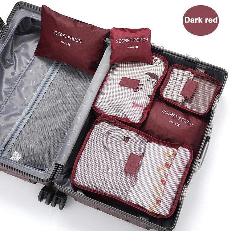 Dark red travel packing cubes organizing folded clothes in a suitcase, mesh covers visible.