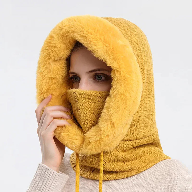 Woman wearing a yellow knit hood with faux fur trim and matching face covering, cozy winter style