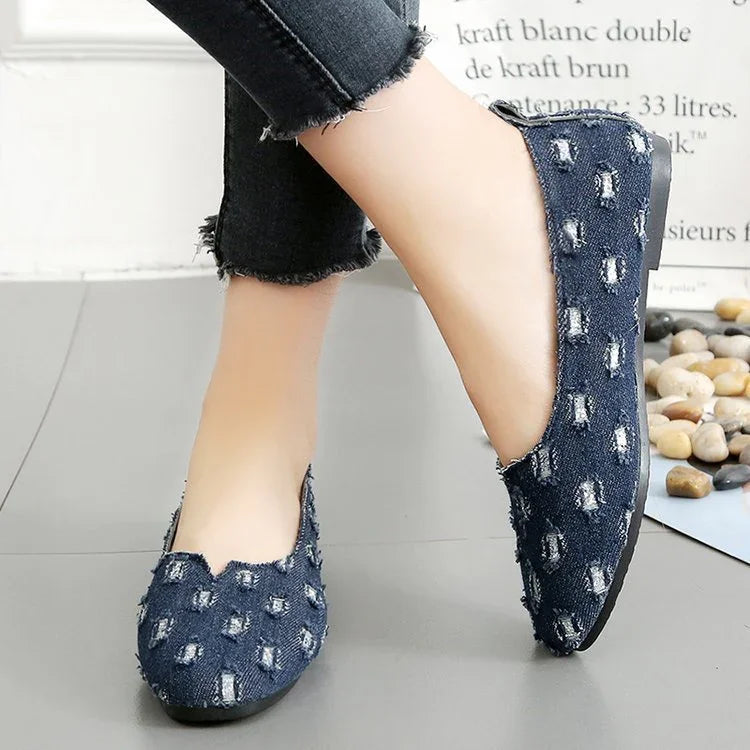 Distressed blue denim slip-on flats with round toe and frayed edge, casual fit