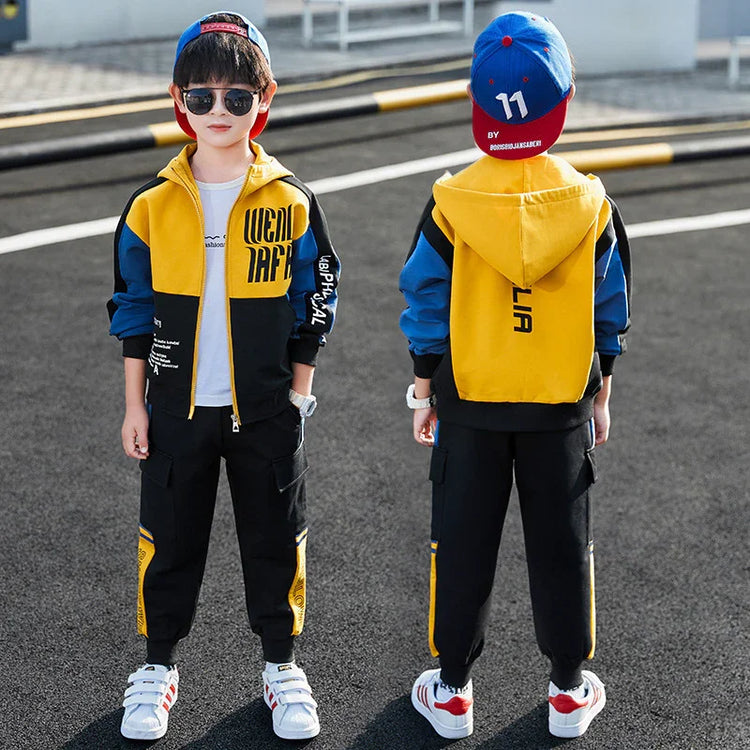 Boy wearing a colorblock yellow, blue, and black streetwear hoodie and jogger set with relaxed fit.