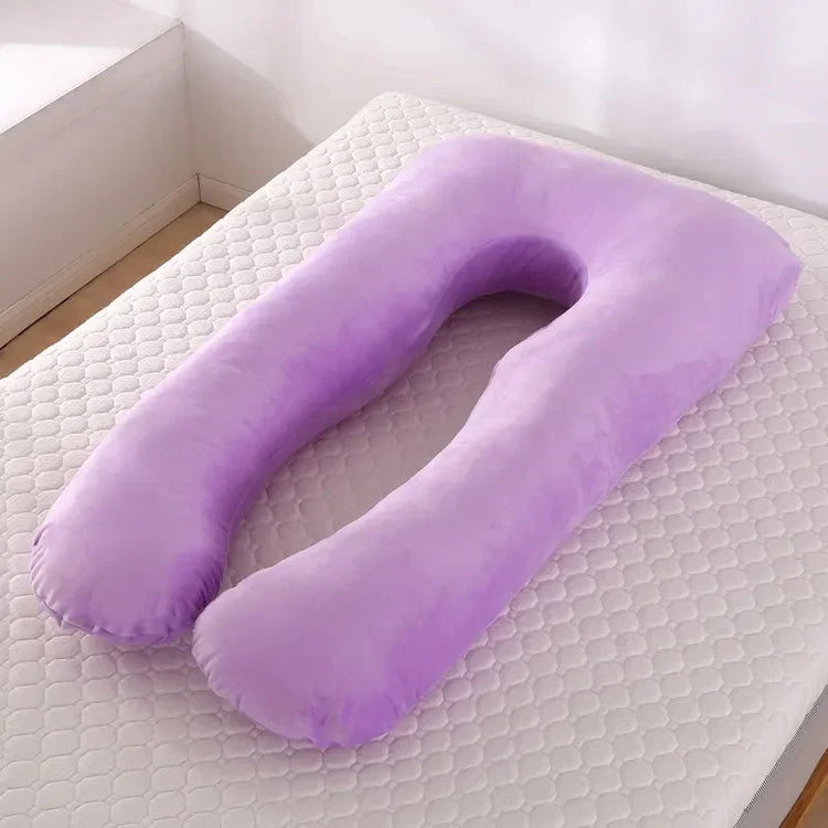 Plush purple U-shaped body pillow with soft fabric, resting on a mattress