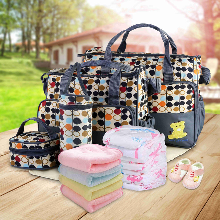 Geometric pattern diaper bags with matching accessories, pastel towels, and baby shoes on table