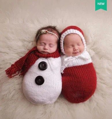 Two babies in cozy knit swaddles, one styled as a snowman, one in red and white.