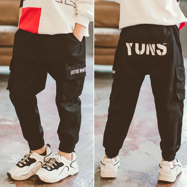 Black cargo jogger pants with bold white lettering, relaxed fit, side pockets, streetwear style