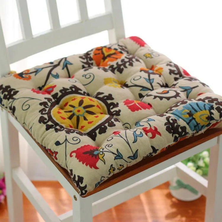 Colorful floral-patterned cotton chair cushion with a soft, tufted design on a white chair