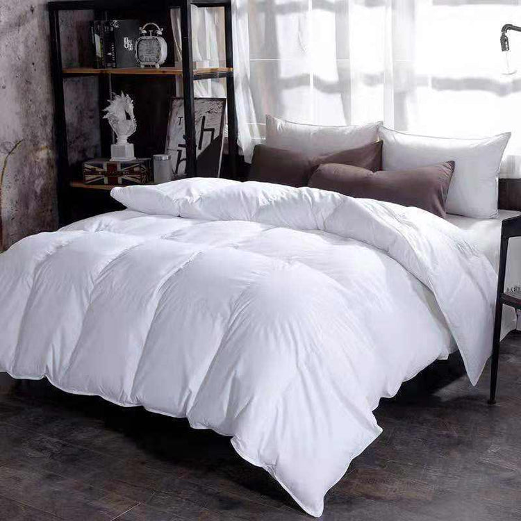 Plush white comforter on bed with brown and white pillows in modern bedroom