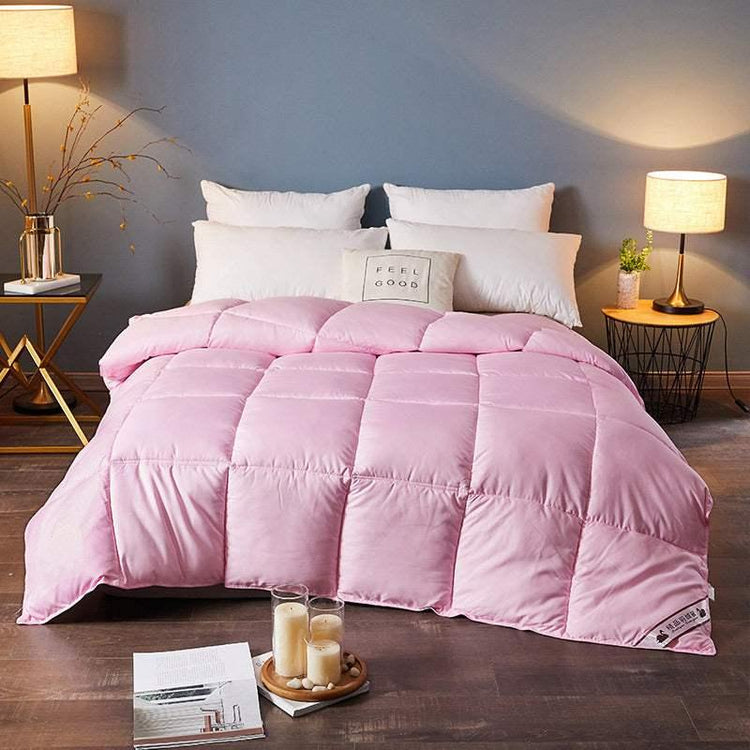 Modern bedroom with a light pink quilted comforter, soft texture, and relaxed fit on bed