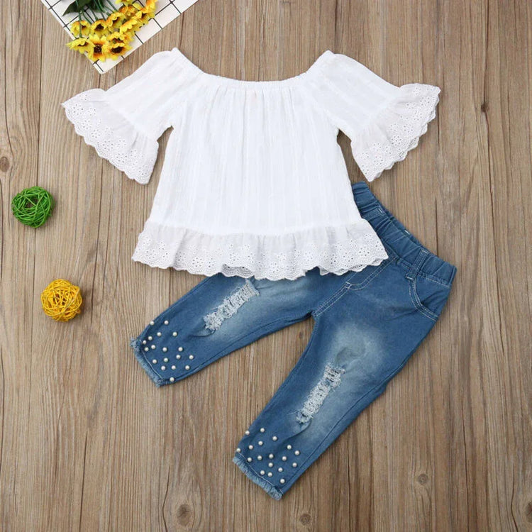 White lace ruffle blouse with flared sleeves and blue distressed pearl-embellished jeans