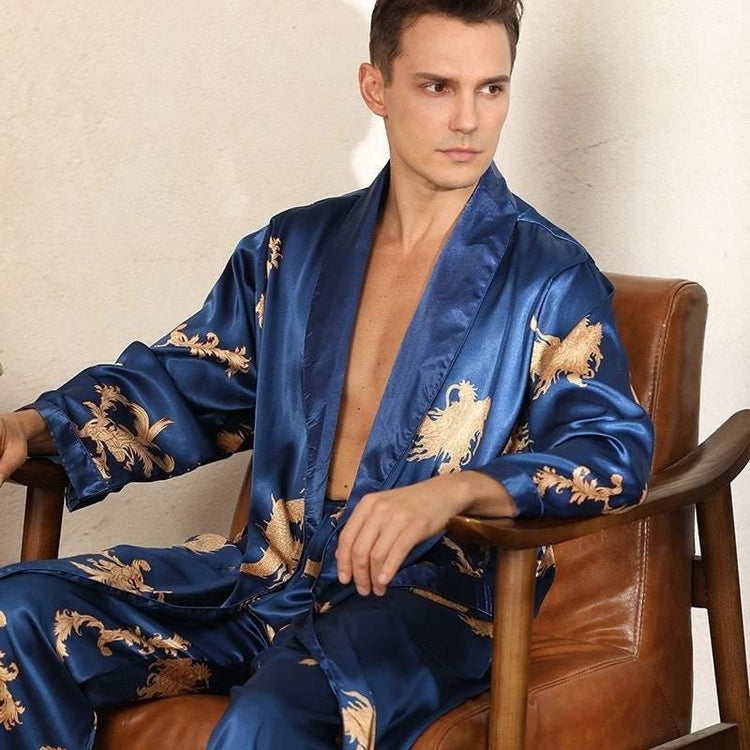 Man wearing blue satin robe with gold dragon embroidery, relaxed fit, sitting on chair