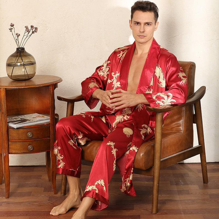 Man wearing red satin lounge set with gold dragon print and relaxed fit, sitting indoors