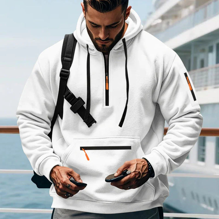 Man wearing a white pullover hoodie with black drawstrings, zipper details, and relaxed fit.
