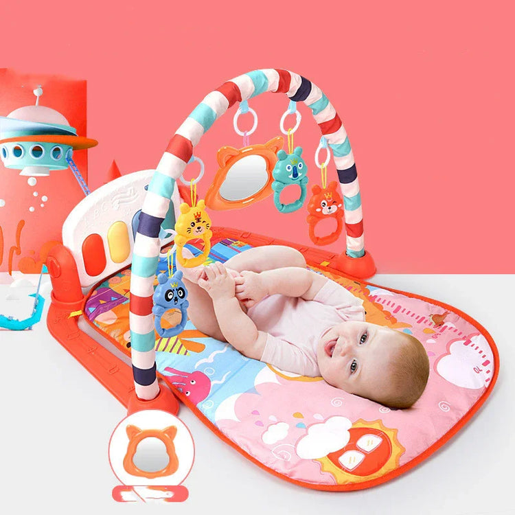 Baby lying on colorful soft play mat with hanging animal toys, short-sleeve bodysuit
