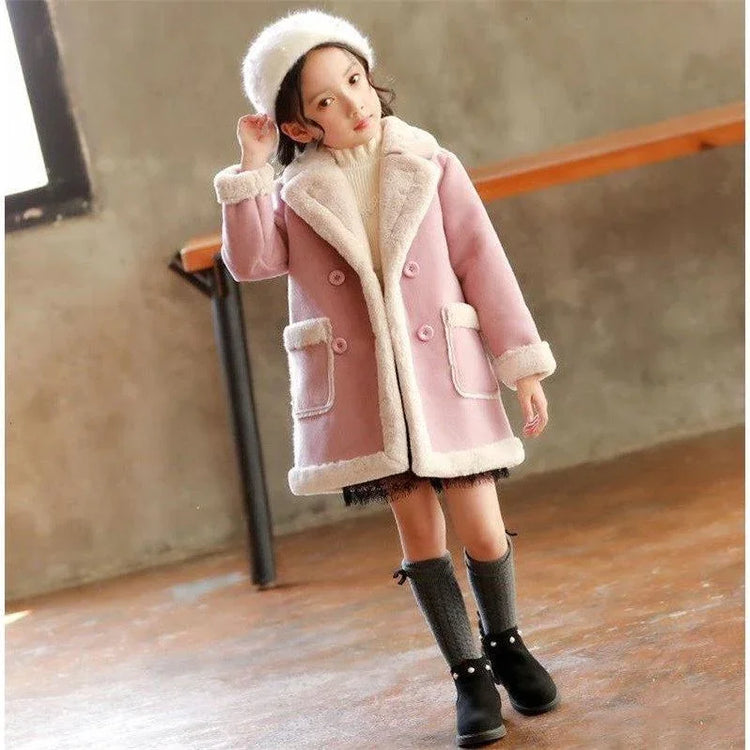 Girl wearing a pink faux fur lined winter coat, white turtleneck, and gray knee socks