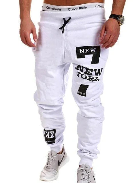 White streetwear jogger pants featuring black New York graphic print, relaxed fit, cotton material