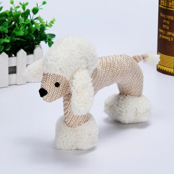 Plush poodle toy with textured beige body, white fluffy ears, tail, and leg cuffs, standing on a white surface.