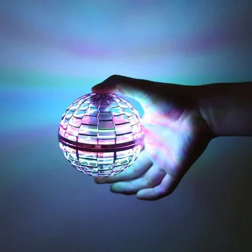 Hand holding a glowing, multicolored LED orb against a dark background