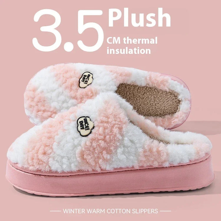 Plush pink and white fuzzy winter slippers with thick thermal soles, cozy cotton material.