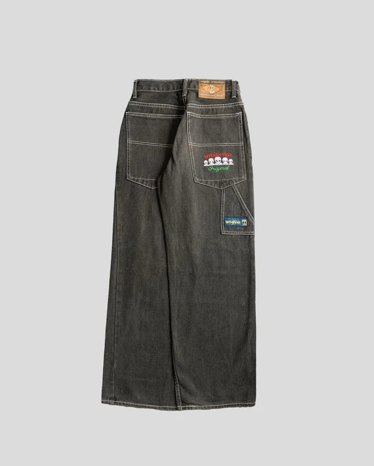 Wide-leg dark denim jeans with white stitching, large patch pockets, and playful embroidered patches on the back.