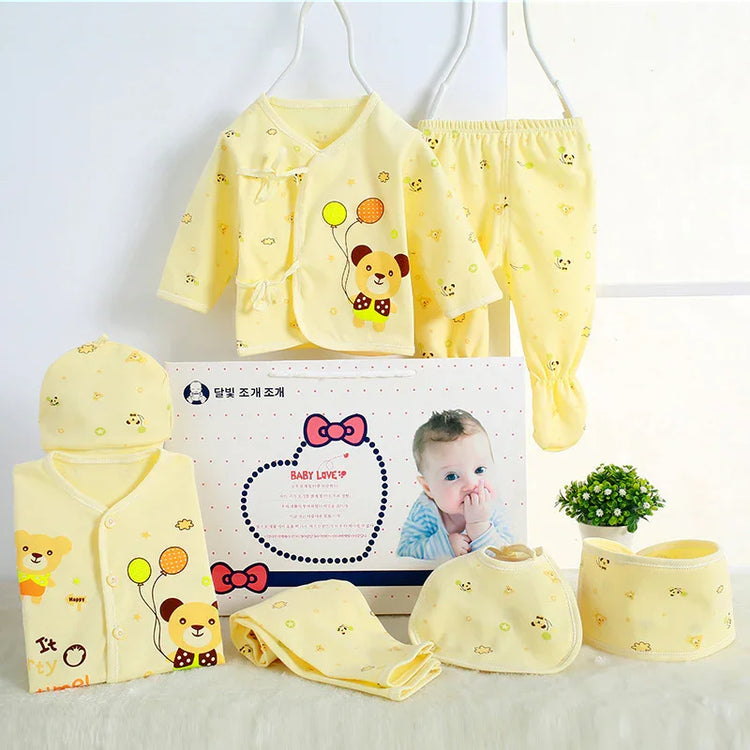 Yellow baby clothing set with bear and balloon print, soft cotton fabric, long sleeve, pants, hat, and bib.