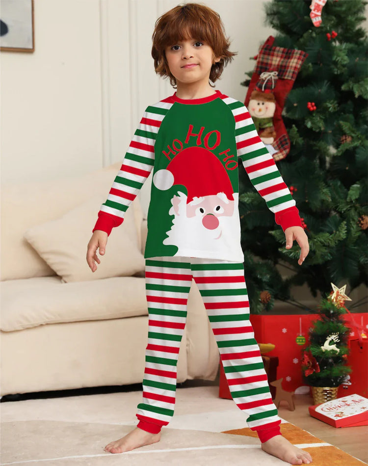 Child wearing festive striped Christmas pajamas with a Santa Claus print and red cuffs.
