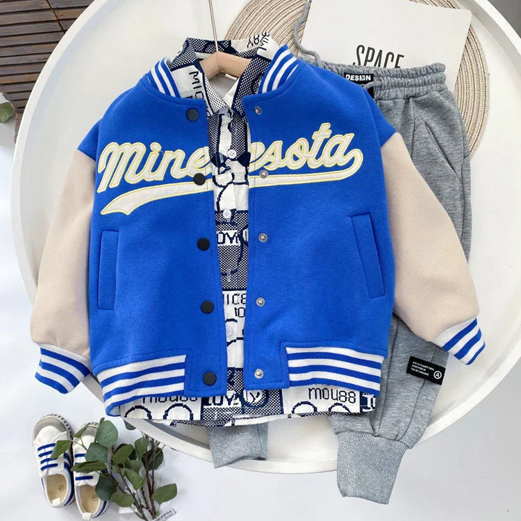 Blue varsity jacket with cream sleeves, striped cuffs, cotton shirt, and grey joggers set
