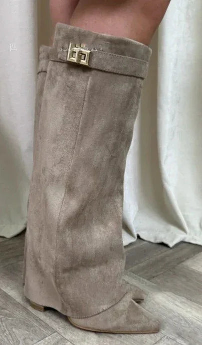 Taupe suede knee-high boots with pointed toe, loose fit, and gold buckle detail