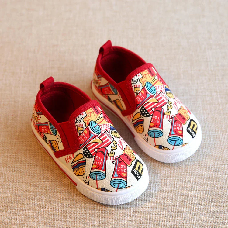 Kids slip-on canvas shoes with red trim, colorful fast food print, flat rubber soles.