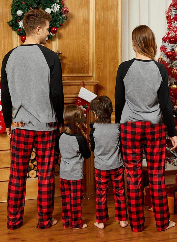 Family in matching grey raglan tops and red plaid pajama pants, cozy cotton fit