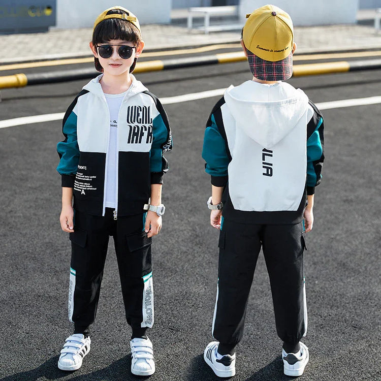 Boy wearing colorblock streetwear tracksuit with teal, black, and white hoodie and joggers