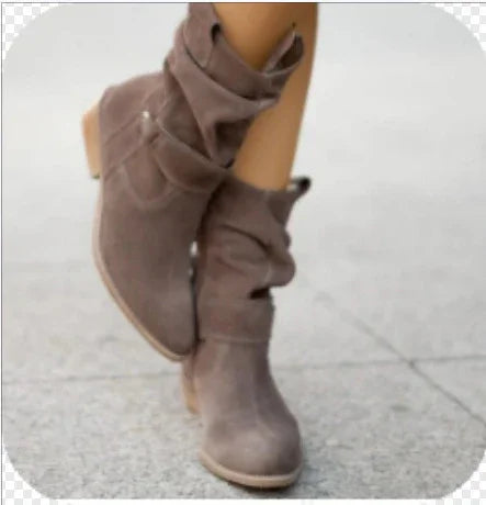 Woman wearing slouchy taupe suede mid-calf boots with low block heels on pavement