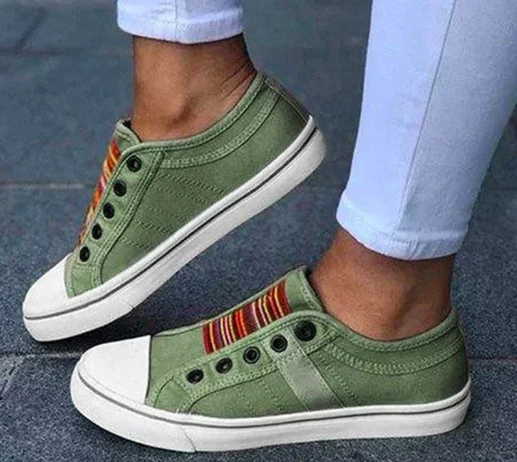 Olive green canvas slip-on sneakers with multicolor striped detail and white sole
