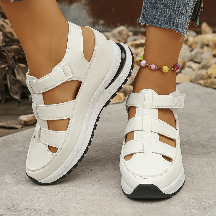 White platform closed-toe sandals with adjustable straps, casual fit, worn with jeans