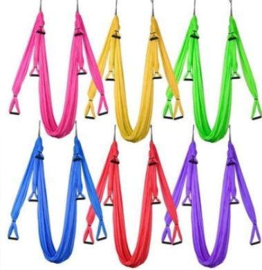 Assorted aerial yoga hammocks in pink, yellow, green, blue, red, and purple, soft fabric material, fitness accessory.