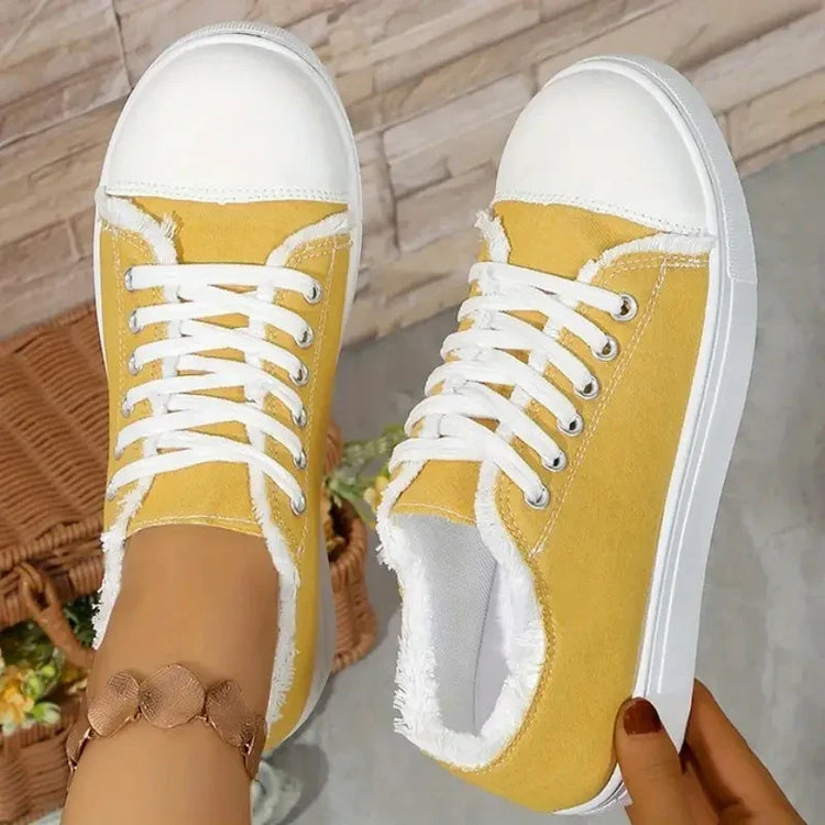 Yellow canvas sneakers with white rubber toes, white laces, raw edge trim, casual fit