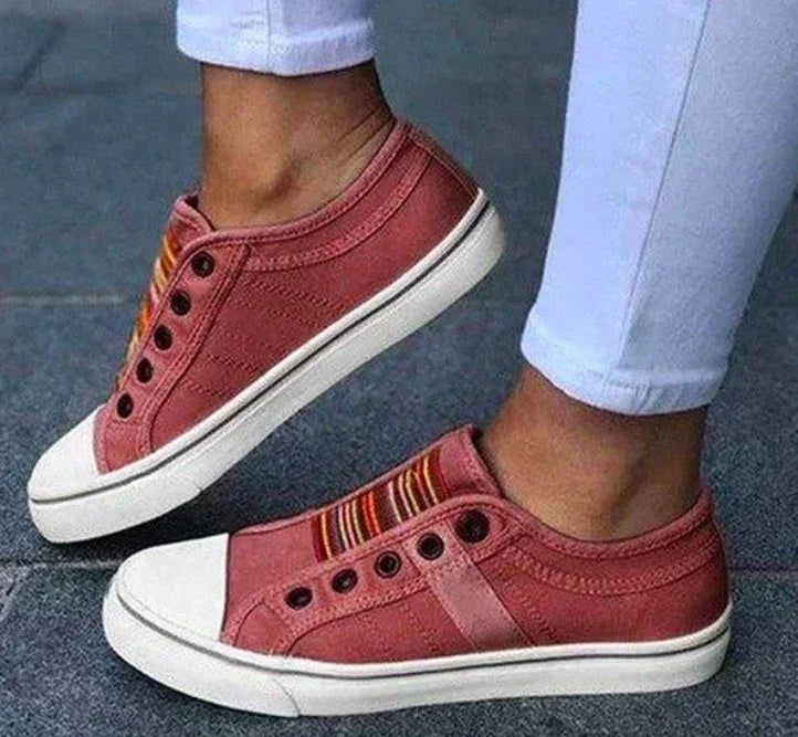 Red canvas slip-on sneakers with striped elastic bands and white soles, casual fit