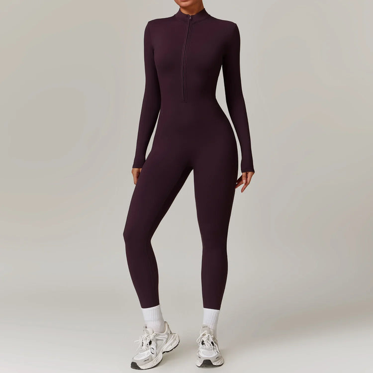 Woman wearing fitted long sleeve dark purple jumpsuit with front zipper, athletic style