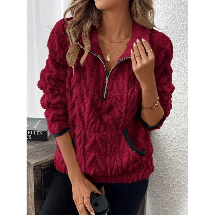 Woman wearing a red textured fleece pullover with half-zip front and relaxed fit