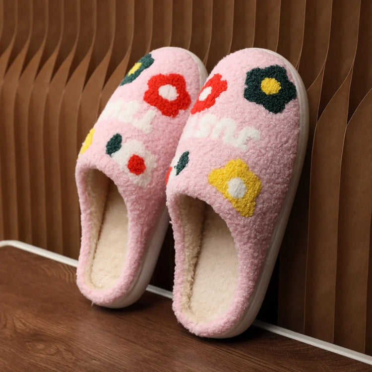 Pink fuzzy slippers with colorful floral patterns, cozy sherpa lining, slip-on style