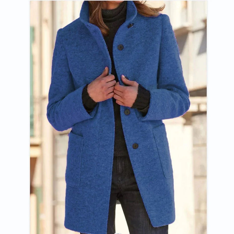 Woman wearing a blue wool coat, tailored fit, with large buttons and front pockets