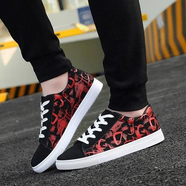 Black and red graphic print low-top sneakers with white soles and laces, casual streetwear style