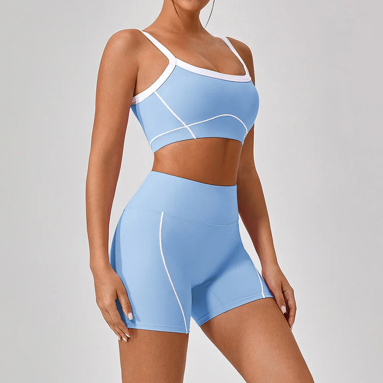 Woman wearing light blue athletic crop top and matching high-waisted shorts with white trim