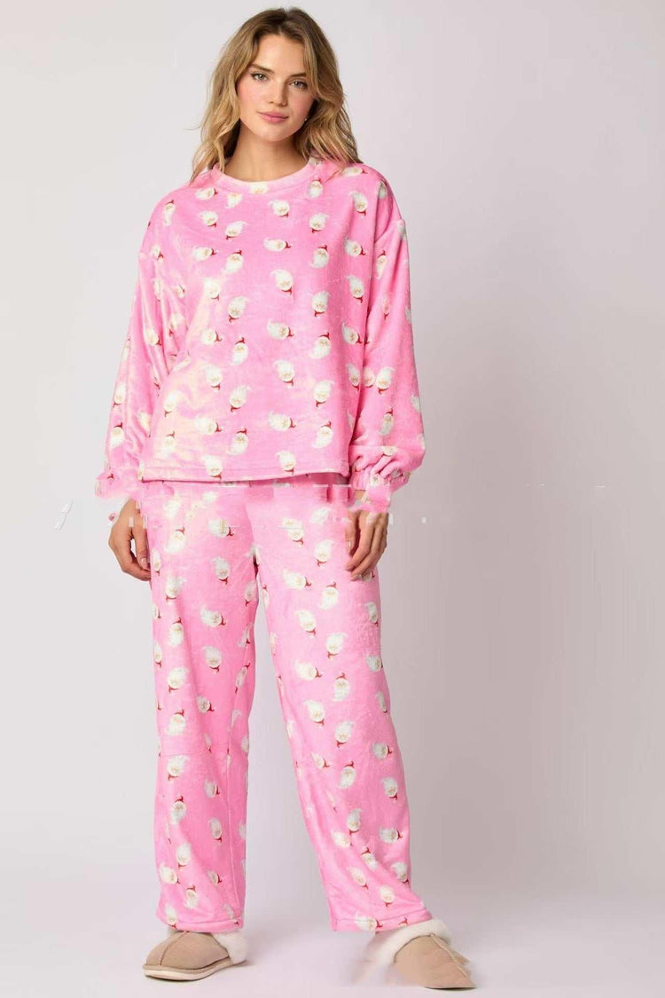 Woman wearing relaxed fit pink fleece pajamas with white sheep pattern and matching pants