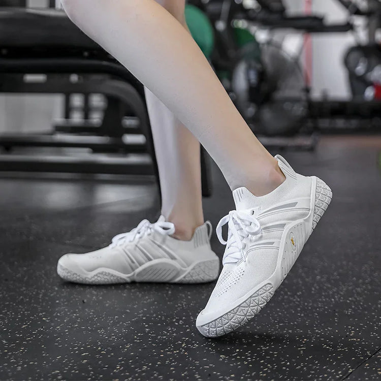 White knit sneakers with textured sole, lace-up style, athletic fit, worn in gym setting