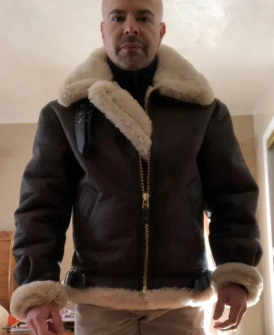 Man wearing a brown shearling aviator jacket with cream fur collar and cuffs, regular fit.