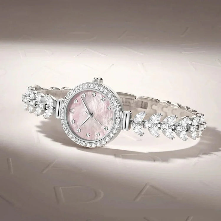 Elegant silver watch with a pink mother-of-pearl dial and crystal-studded bracelet